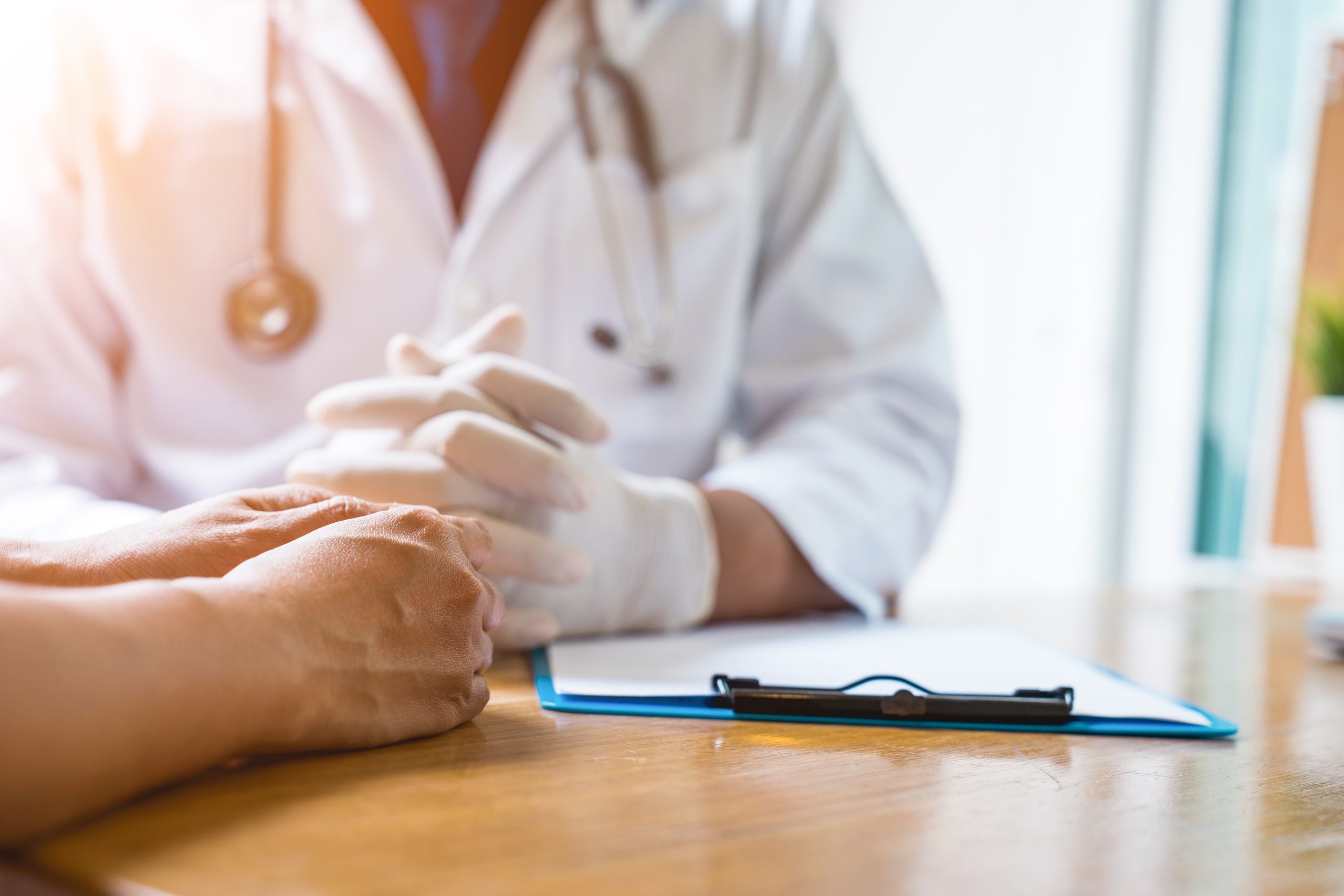 A doctor is working in the hospital, he is wearing a brown stethoscope and he is investigating the illness of the patient.